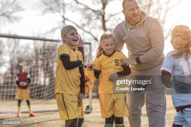 middle aged redhead father coaching soccer to a girl football team at training - hobby stock pictures, royalty-free photos & images