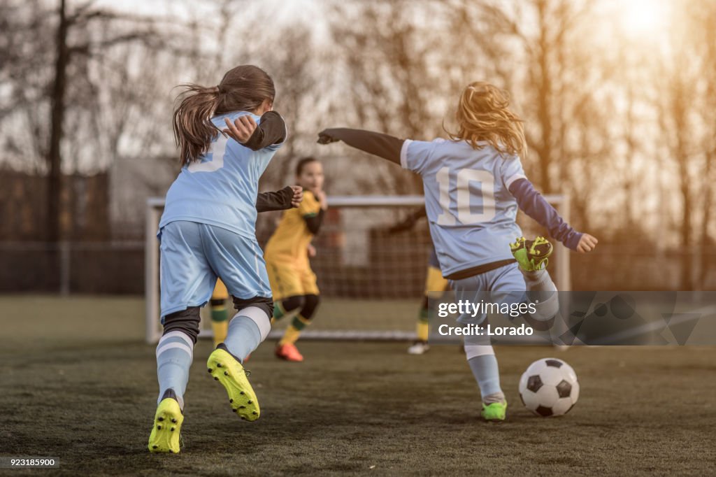 Two Female Girl Soccer Teams playing a football training match in the Spring outdoors