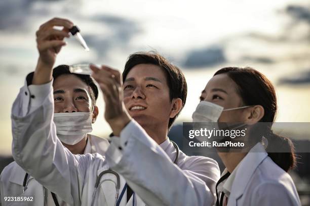 doctor putting liquid in petri dish - glory tube stock-fotos und bilder