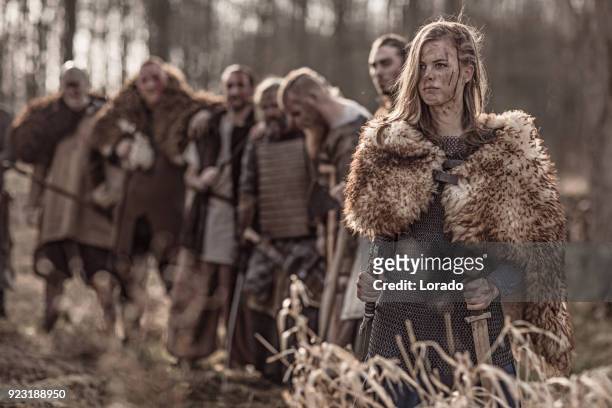 beautiful viking warrior royal female with her army on a winter battlefield forest - viking stock pictures, royalty-free photos & images