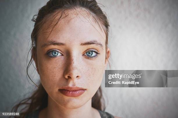 bella bruna dagli occhi azzurri in piedi da parete strutturata sembra triste - brunette woman foto e immagini stock
