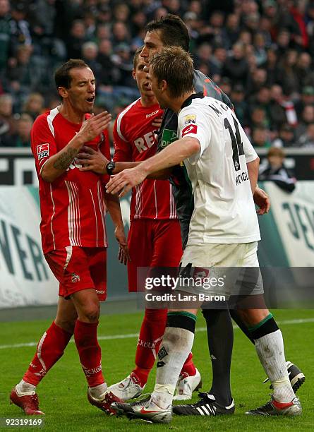 Petit and Lukas Podolski of Koeln discuss with Thorben Marx of Moenchengladbach during the Bundesliga match between Borussia Moenchengladbach and 1....
