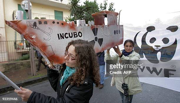 People carry a fake boat named "Nigthmare" as part of a demonstration in which some thousand of people, whose including ecologists, politicians and...