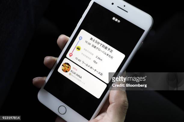 Smartphone screen displaying trip information is arranged for a photograph during a test drive of the "Easy Ride" robot taxi service, jointly...