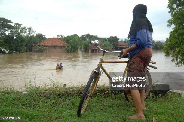 Residents cross the flood that struck the village of Danareja, Brebes, Central Java In February, 23.2018. Hundreds of homes and agricultural lands...