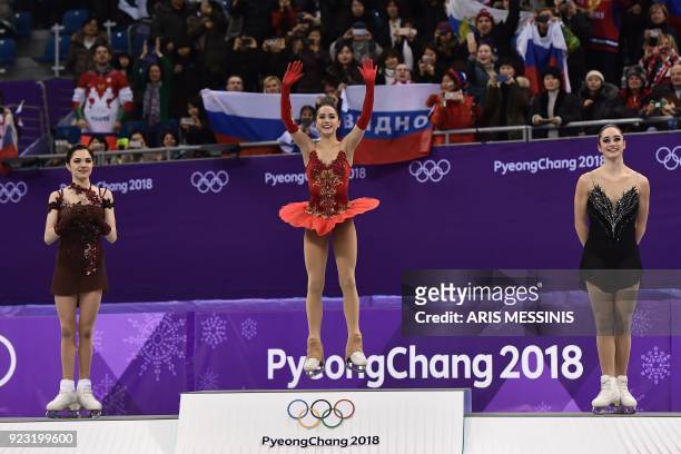 Silver medallist Russia's Evgenia Medvedeva, gold medallist Russia's Alina Zagitova and bronze medallist Canada's Kaetlyn Osmond celebrate on the...