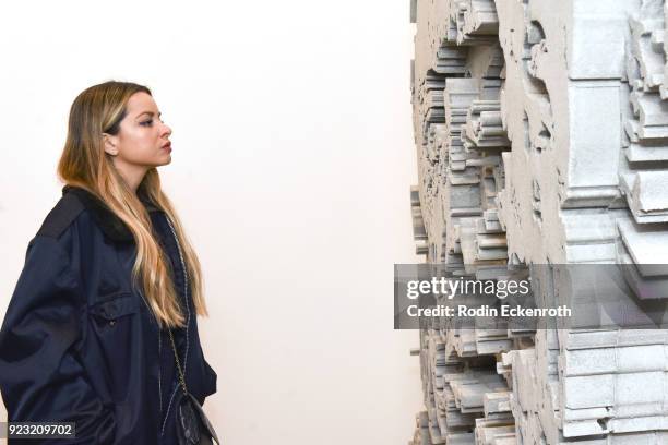 An attendee enjoys art at the opening reception for Vhil's "Annihilation" exhibit at Over The Influence on February 22, 2018 in Los Angeles,...