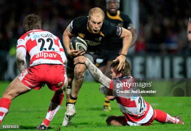 Wasps scrumhalf Joe Simpson gets through the tackles from Warren Fury and Eoghan Hickey during the Guinness Premiership match between Gloucester and...