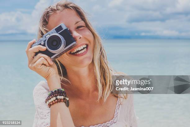 girl taking a photo at sea with a film camera - camera girls stock pictures, royalty-free photos & images