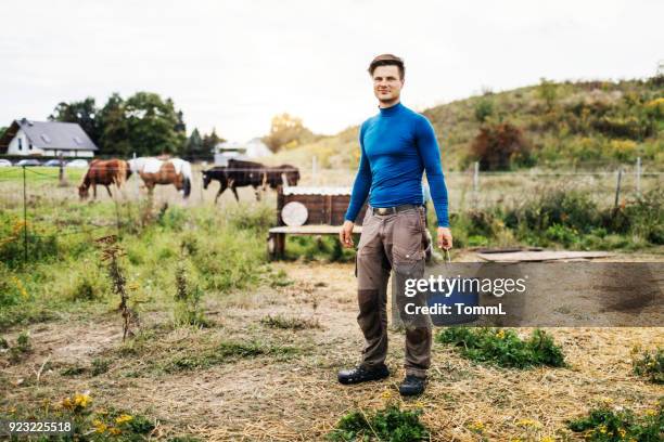 portret van een jonge boer die emmer - holding horse stockfoto's en -beelden