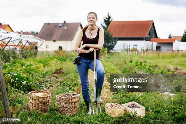 Portrait Of Urban Farmer Standing With Days Harvest