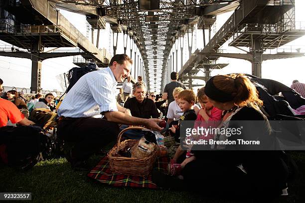 Premier Nathan Rees hands out food to a family during a picnic breakfast on the Sydney Harbour Bridge on October 25, 2009 in Sydney, Australia. For...