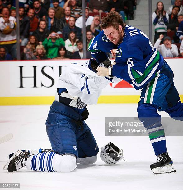 Tanner Glass of the Vancouver Canucks drops the gloves against Luke Schenn of the Toronto Maple Leafs during their game at General Motors Place on...