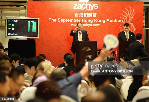 To go with Lifestyle-China-HongKong-France-wine-investment by Polly Hui In a picture taken on September 12, 2009 a bidder raises his paddle during a...