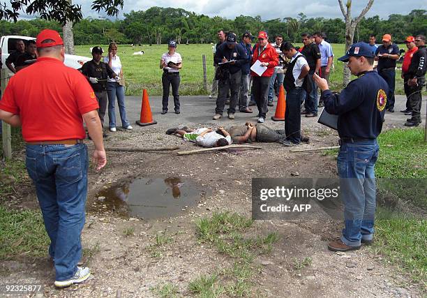 Police agents inspect two of ten, bodies found in the state of Tachira, bordering with Colombia, on October 24, 2009. The bodies could belong to 10...