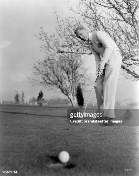 Otto Kruger, best golfer at the Metro-Goldwyn-Mayer studios in action. Photograph. Around 1935.