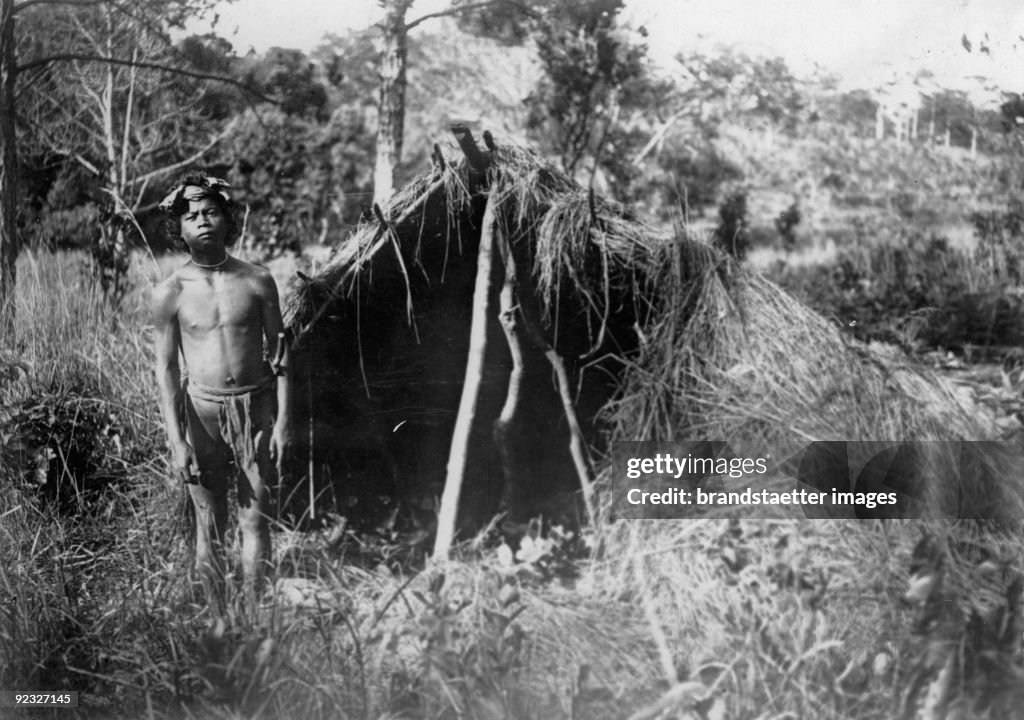 Indigene man with his thatched hut. Erstwhile Indochina. Photograph. Around 1930.