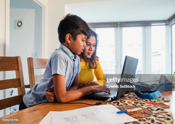 helping her son with homework - bangladeshi culture stock pictures, royalty-free photos & images