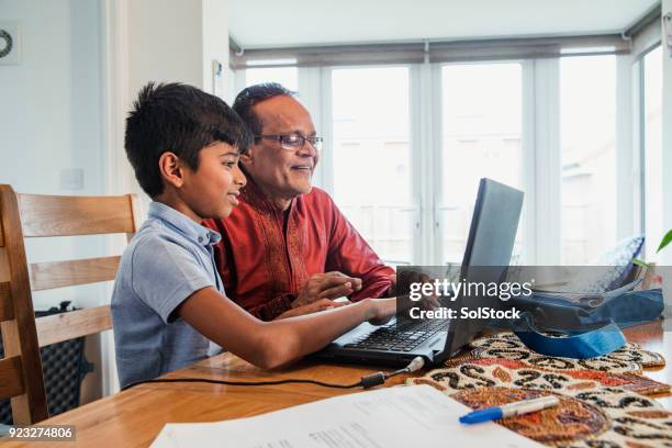 helpen met huiswerk kleinzoon - muslim boy stockfoto's en -beelden