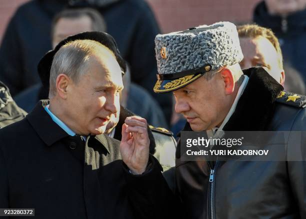 Russian President Vladimir Putin speaks to Defence Minister Sergey Shoygu during a wreath laying ceremony at the Tomb of the Unknown Soldier near the...