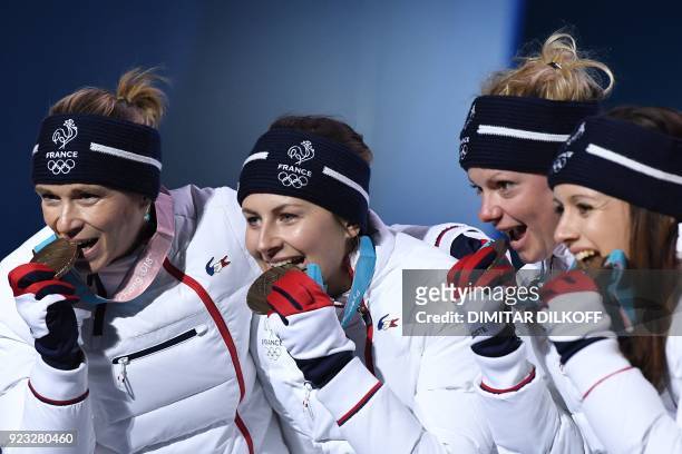 France's bronze medallists Anais Chevalier, Marie Dorin Habert, Justine Braisaz and Anais Bescond pose on the podium during the medal ceremony for...