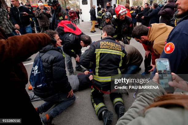 Firefighters attend an injured man during a protest called by the 'Commitees in defence of the Republic' to block the TSJC in Barcelona on February...