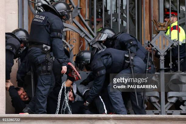 Catalan regional police officers remove two chained men during a protest called by the 'Commitees in defence of the Republic' to block the TSJC in...