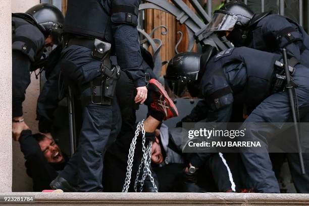 Catalan regional police officers remove two chained men during a protest called by the 'Commitees in defence of the Republic' to block the TSJC in...