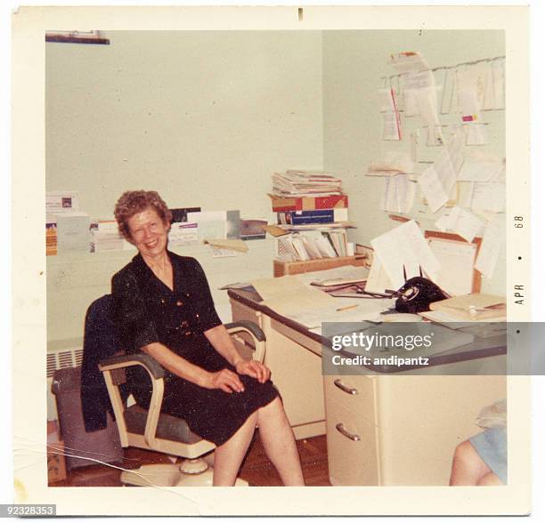 vintage photograph of an happy secretary sitting at her desk - 1950 woman bildbanksfoton och bilder