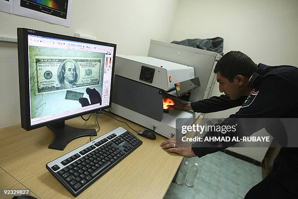 Member of Iraq's Crime Scene Investigation unit examines a 100-dollar bill at a laboratory at the Baghdad police academy on October 21, 2009. Still...