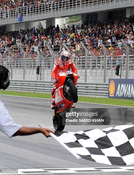 Australian Ducati Marlboro rider Casey Stoner celebrates his race victory at the finish line of the Malaysian Motocycle Grand Prix at the Sepang...