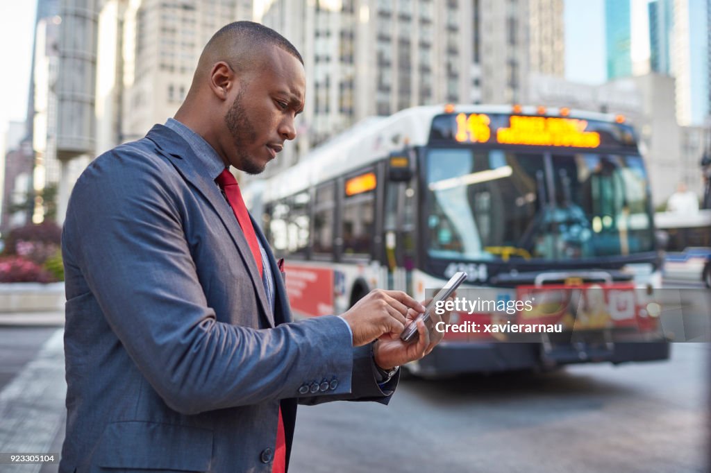 Geschäftsmann mit Taxi-app in der Innenstadt von Chicago