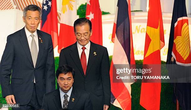 Chinese Prime Minister Wen Jiabao walks between Thai Prime Minsister Abhisit Vejjajiva and Singaporean Prime Minister Lee Hsien Loong at the...