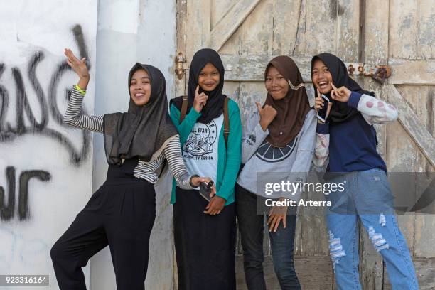 Happy modern dressed young Indonesian girls wearing jilbab - hijab, Semarang, Java, Indonesia.