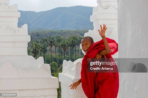 Happy novice monk smiling in the Hsinbyume pagoda - Myatheindan pagoda, temple in Mingun near Mandalay in Sagaing Region in central Myanmar - Burma.