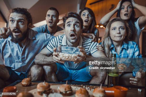 grote groep jongeren een sport wedstrijd thuis op tv kijken. - pre game stockfoto's en -beelden