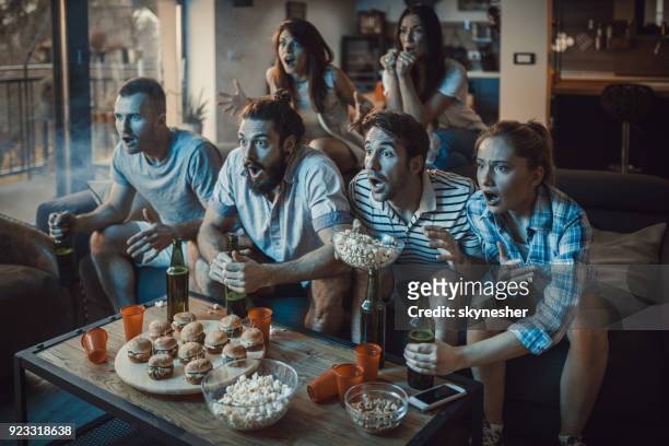 grote groep sportfans kijken naar een wedstrijd op tv thuis. - pre game stockfoto's en -beelden