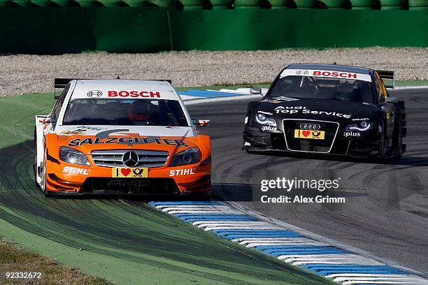 Mercedes driver Gary Paffett of Britain leads the race ahead of Audi driver Timo Scheider of Germany during the final run of the DTM 2009 German...