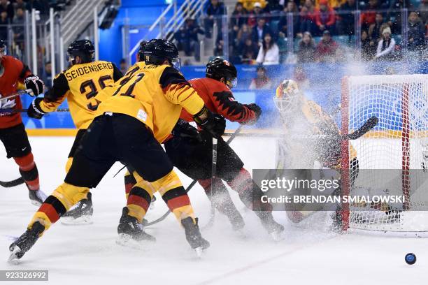 Germany's Danny aus den Birken makes a save past Canada's Wojciech Wolski in the men's semi-final ice hockey match between Canada and Germany during...