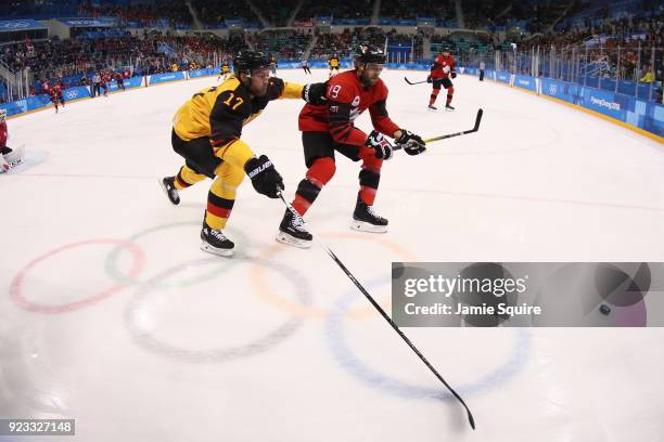 Andrew Ebbett of Canada fights for control of the puck with Marcus Kink of Germany in the first period during the Men's Play-offs Semifinals on day...