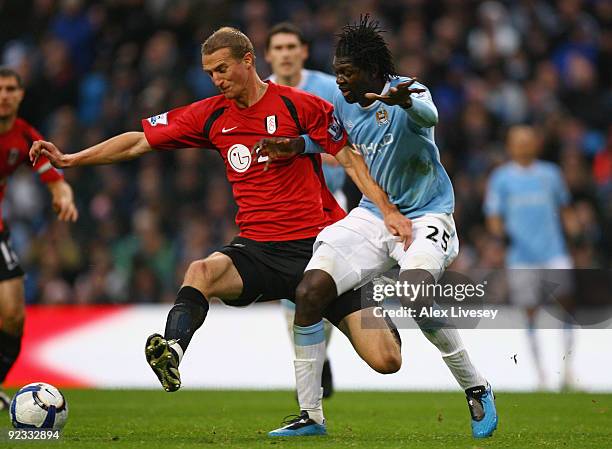 Brede Hangeland of Fulham holds off a challenge from Emmanuel Adebayor of Manchester City during the Barclays Premier League match between Manchester...