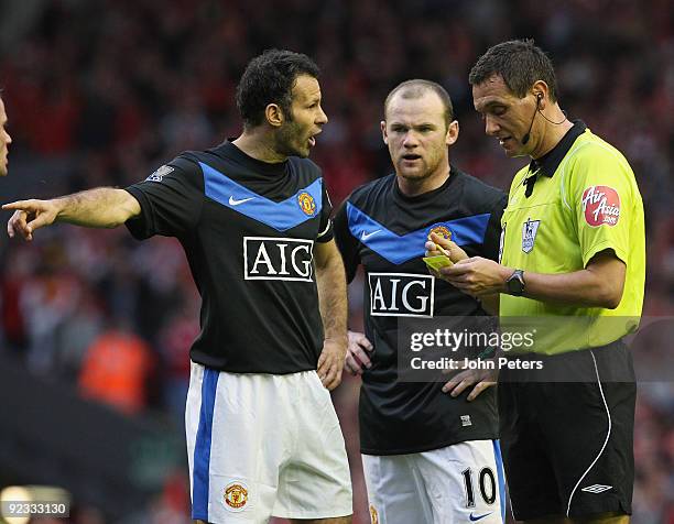 Ryan Giggs and Wayne Rooney of Manchester United complain to referee Andre Marriner during the FA Barclays Premier League match between Liverpool and...