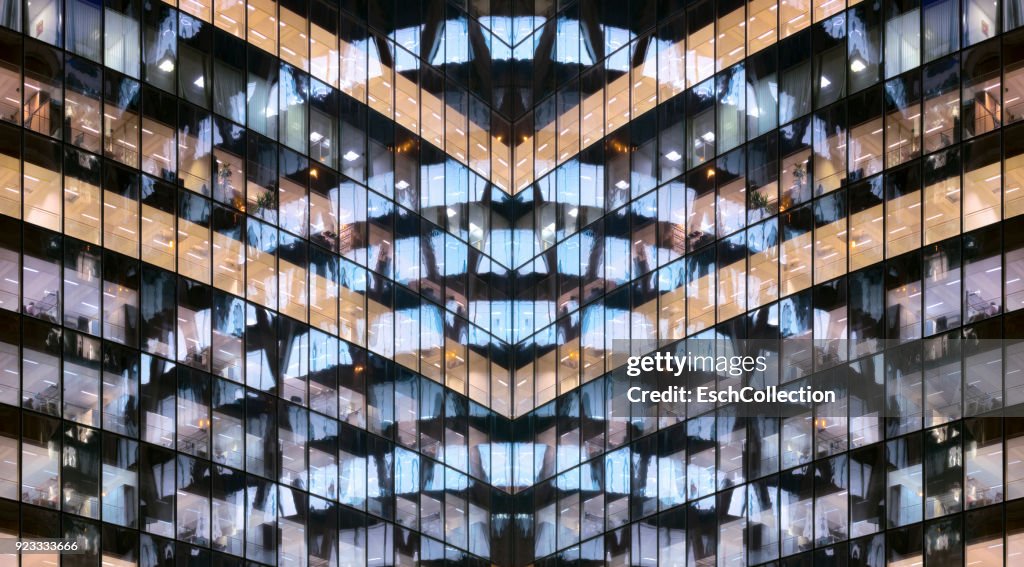 Reflections in glass office facade at dusk
