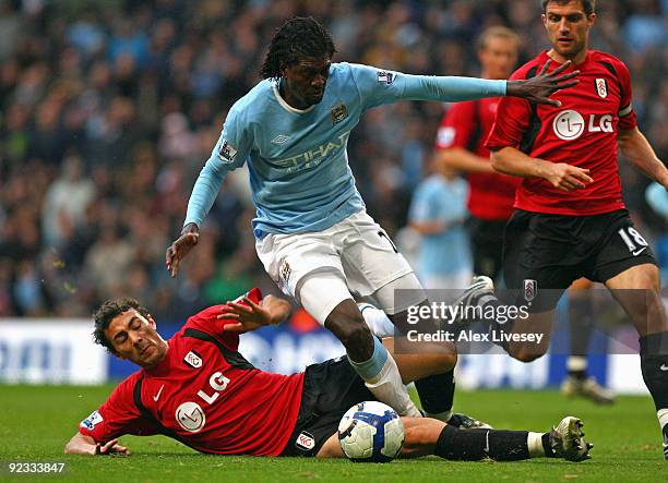 Emmanuel Adebayor of Manchester City is tackled by Stephen Kelly of Fulham during the Barclays Premier League match between Manchester City and...