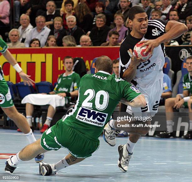 Daniel Narcisse of Kiel challenges for the ball with Rares Jurca of Goeppingen during the Toyota Handball Bundesliga match between THW Kiel and...