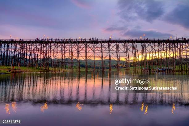 beautiful sunset scene at old an long wooden bridge at sangklaburi,kanchanaburi province, thailand - monsees stock-fotos und bilder