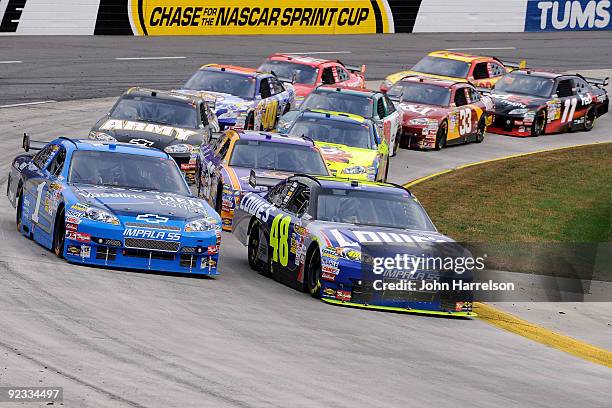 Jimmie Johnson, driver of the Lowe's Chevrolet, and Martin Truex Jr., driver of the Vaseline MEN Body Lotion Chevrolet, lead a group of cars during...