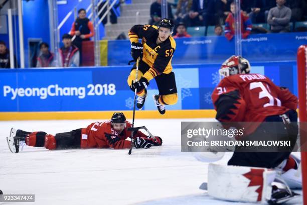 Germany's Marcel Goc jumps over Canada's Maxim Noreau in the men's semi-final ice hockey match between Canada and Germany during the Pyeongchang 2018...