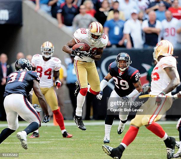 Wide receiver Isaac Bruce of the San Francisco 49ers completes a reception in front of cornerback Glover Quin and Bernard Pollard of the Houston...