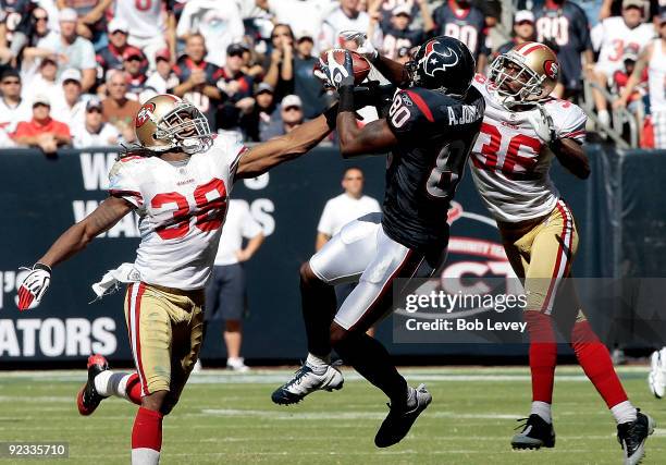 Wide receiver Andre Johnson of the Houston Texans completes a 44 yard reception between safety Dashon Goldson and cornerback Shawntae Spencer of the...